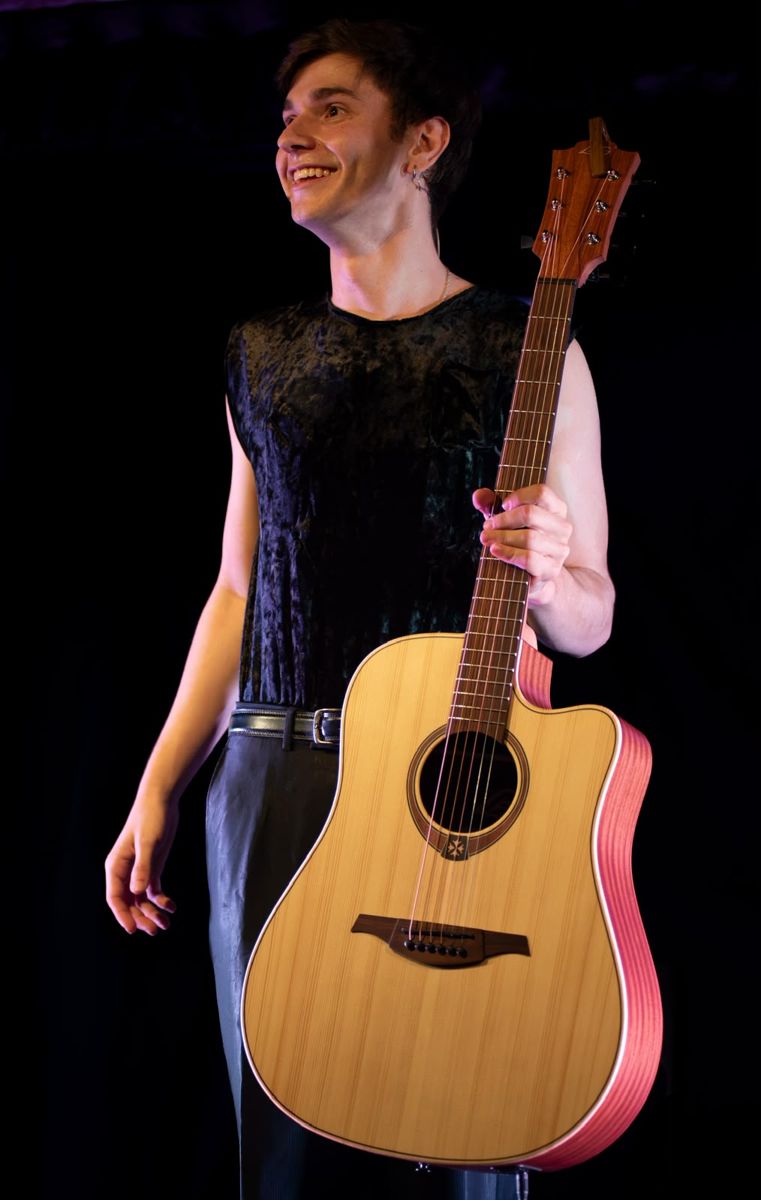 Pol Pavo somrient amb la guitarra a l'escenari